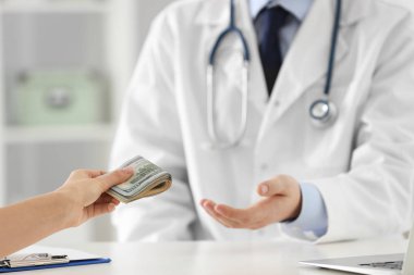 Hasta klinikteki doktora rüşvet veriyor, yakın plan. Yozlaşmış tıp