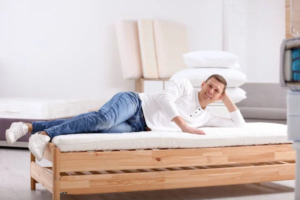 Mannen testar mjuk madrass i möbelaffär — Stockfoto