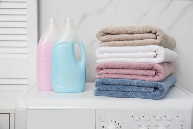 Stack of fresh towels and detergents in laundry room