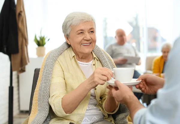 Îngrijitorul care dă băutură unei femei în vârstă din ospiciul geriatric — Fotografie, imagine de stoc