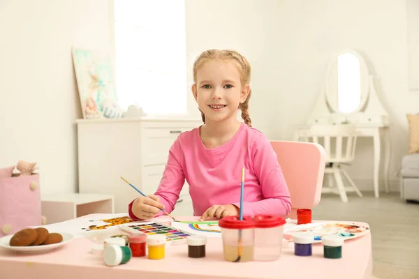 Cute little child painting at table in room — Stok fotoğraf