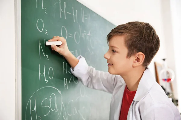 Schüler schreibt chemische Formeln auf Tafel im Klassenzimmer — Stockfoto