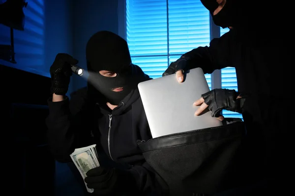 A tolvajok pénzt és laptopot vesznek ki az acélszéfből. — Stock Fotó