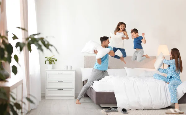 Família feliz ter travesseiro luta no quarto — Fotografia de Stock