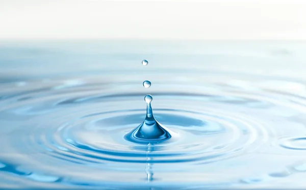 Salpicadura de agua clara con gotas como fondo, primer plano —  Fotos de Stock