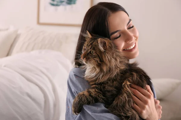 Mooie jonge vrouw met haar schattige kat in de slaapkamer. pluizig huisdier — Stockfoto