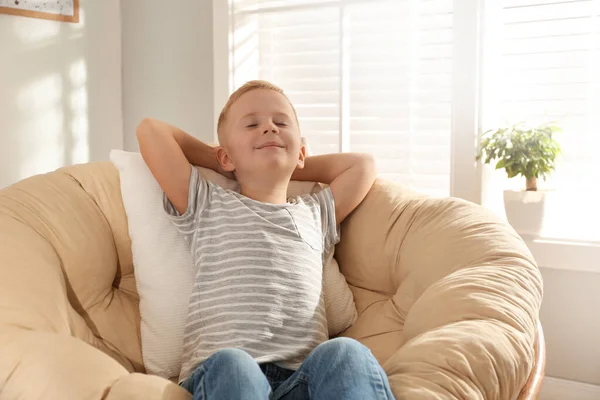 Mignon petit garçon relaxant dans une chaise papasan à la maison — Photo