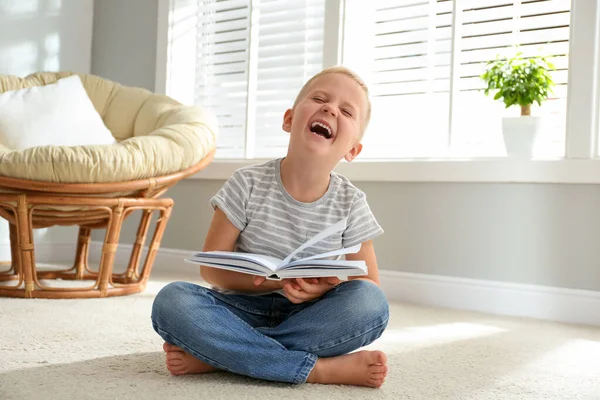 Schattige kleine jongen lezen boek op verdieping thuis — Stockfoto