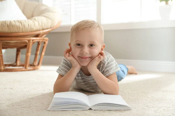 Aranyos kisfiú könyvével emeleten otthon — Stock Fotó