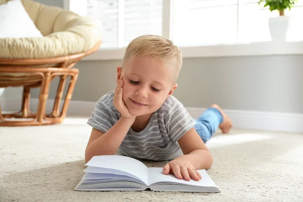 Милий маленький хлопчик читає книгу на підлозі вдома — стокове фото