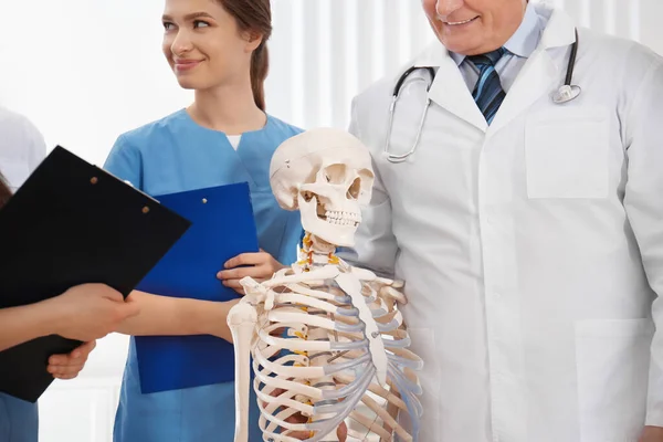 Ortopedico professionista con modello di scheletro umano che insegna medi — Foto Stock