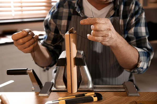 Hombre costura pieza de cuero en el taller, primer plano — Foto de Stock