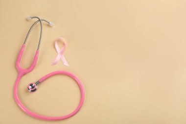 Bej arka planda pembe kurdele ve steteskop, S ile düz yatıyordu.