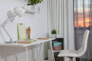 Pencerenin yanında rahat bir iş yeri olan şık bir oda. Tasarım fikri