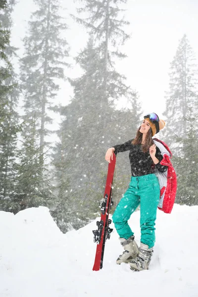 Young woman with skis wearing winter sport clothes outdoors — Stock Photo, Image