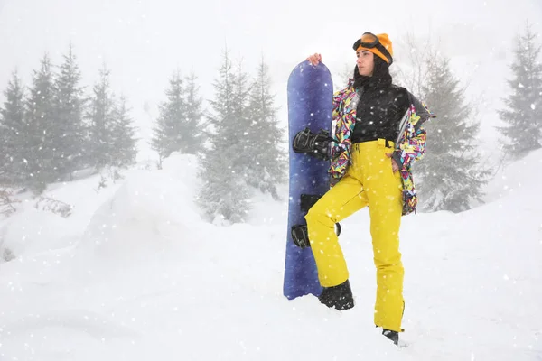 Giovane donna con snowboard che indossa abiti sportivi invernali all'aperto — Foto Stock