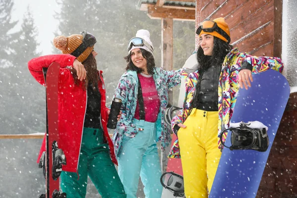 Друзі з лижами та сноубордами носять зимовий спортивний одяг — стокове фото