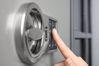 Çelik kasayı elektronik kilitle açan kadın, yakın plan.