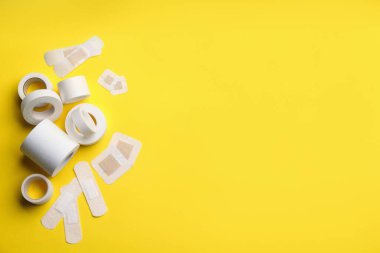 Sarı arka planda farklı tip yapıştırma alçıları, düz yatış. Metin için boşluk