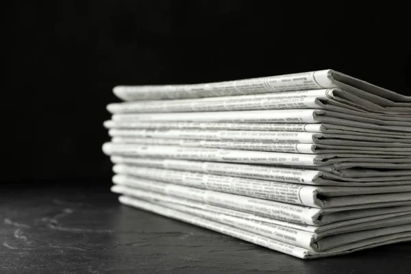 Montón de periódicos en la mesa de piedra oscura. Trabajo periodístico —  Fotos de Stock