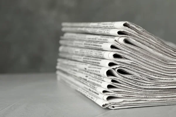 Pilha de jornais em mesa de pedra cinza claro, close-up. Jornalismo — Fotografia de Stock