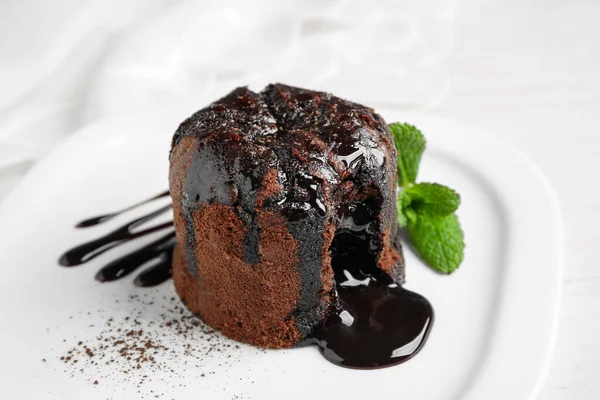 Delicious warm chocolate lava cake on plate, closeup