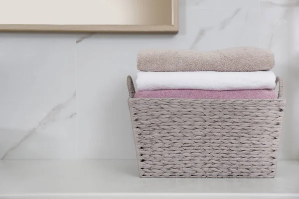 Kosz na pranie ze świeżymi ręcznikami na ladzie w łazience — Zdjęcie stockowe