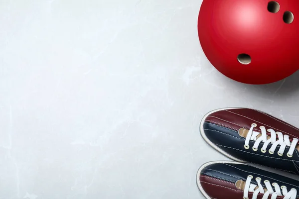 Bowling palla e scarpe su sfondo di marmo grigio chiaro, posa piatta — Foto Stock