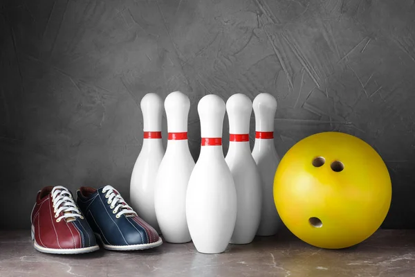 Bowlingové boty, kolíky a koule na šedém mramorovém stole — Stock fotografie