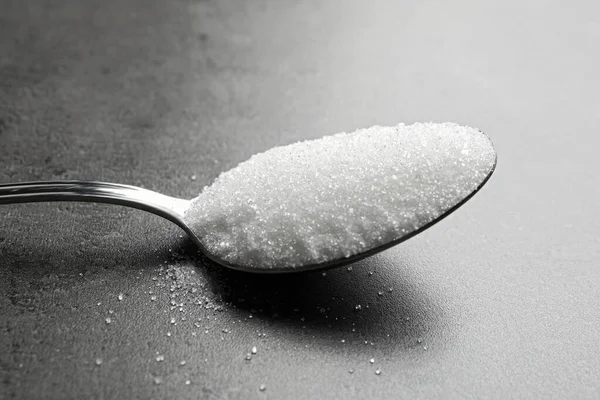 灰色のテーブルの上の白い砂糖のスプーン、クローズアップ — ストック写真