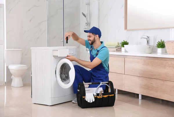 Profi-Klempner repariert Waschmaschine im Badezimmer — Stockfoto
