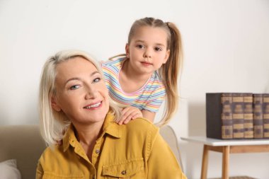 Yetişkin bir kadın ve küçük torunu evde.