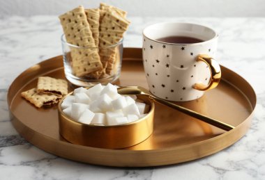 Rafine şeker küpleri kasede ve beyaz mermer sekmede aromatik çay.
