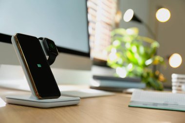 Akıllı telefonu olan ve kablosuz ağda şarj olan modern işyeri
