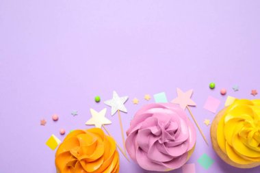 Colorful birthday cupcakes on lilac background, flat lay. Space 
