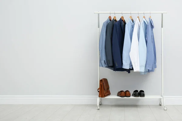 Rack with stylish men's clothes in room. Space for text — Stock Photo, Image