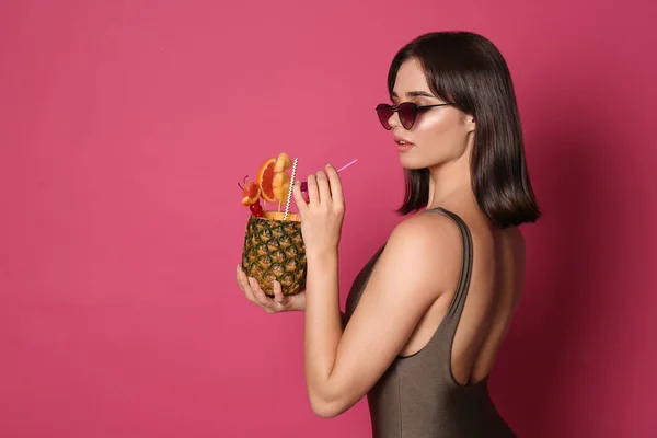 Schöne junge Frau mit exotischem Cocktail im Badeanzug und — Stockfoto