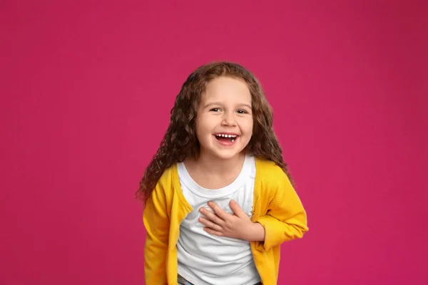 Porträtt av söt liten flicka på rosa bakgrund — Stockfoto