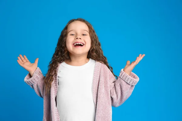 Porträt des niedlichen kleinen Mädchens auf hellblauem Hintergrund — Stockfoto