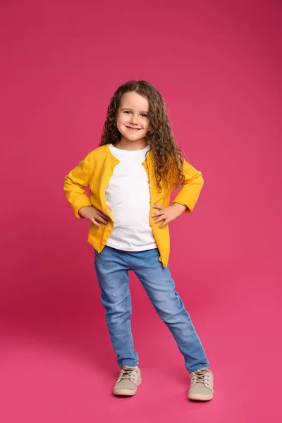 Full längd porträtt av söt liten flicka på rosa bakgrund — Stockfoto