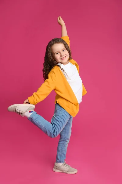 Full längd porträtt av söt liten flicka på rosa bakgrund — Stockfoto