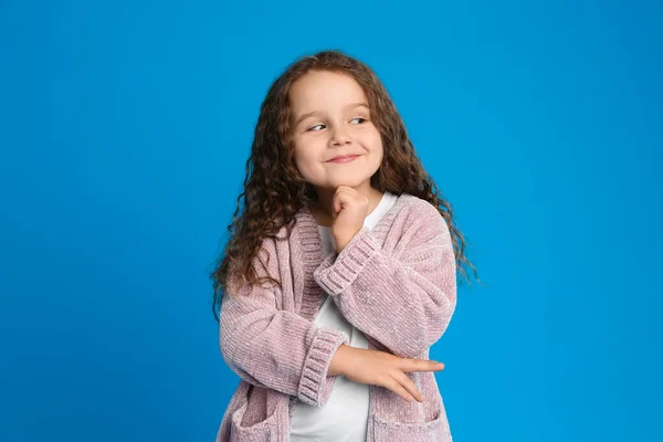 Porträtt av söt liten flicka på ljusblå bakgrund — Stockfoto