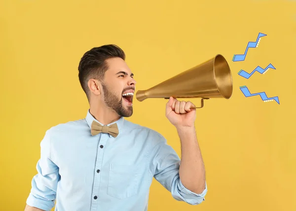 Jovem com megafone no fundo amarelo — Fotografia de Stock