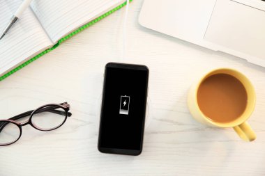 Cep telefonu ve kablosuz şarj cihazıyla düz konum
