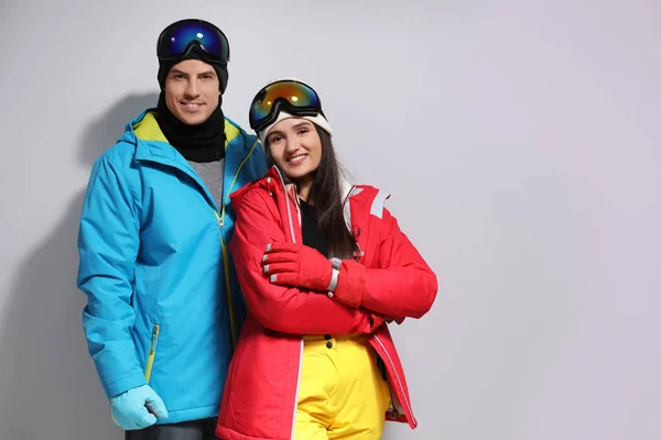 Пара в стильной зимней спортивной одежде на светло-сером бэкгре — стоковое фото
