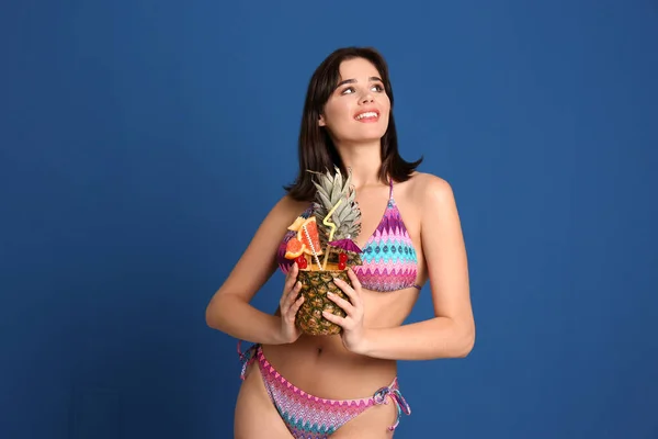 Mooie jonge vrouw met exotische cocktail dragen bikini op blu — Stockfoto