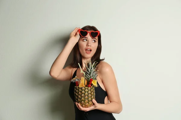 Schöne Frau im stylischen Badeanzug mit tropischem Cocktail — Stockfoto