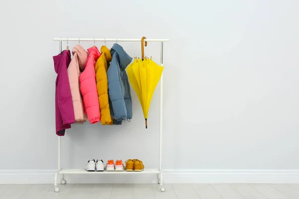 Rack with warm jackets in room. Space for text — Stock Photo, Image