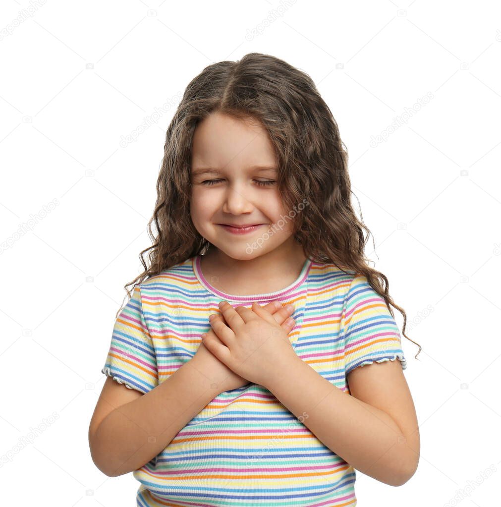 Cute grateful little girl with hands on chest, white background