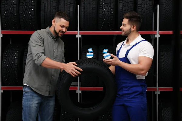 Mechanik Pomaga Klientowi Wybrać Oponę Samochodową Sklepie Samochodowym — Zdjęcie stockowe